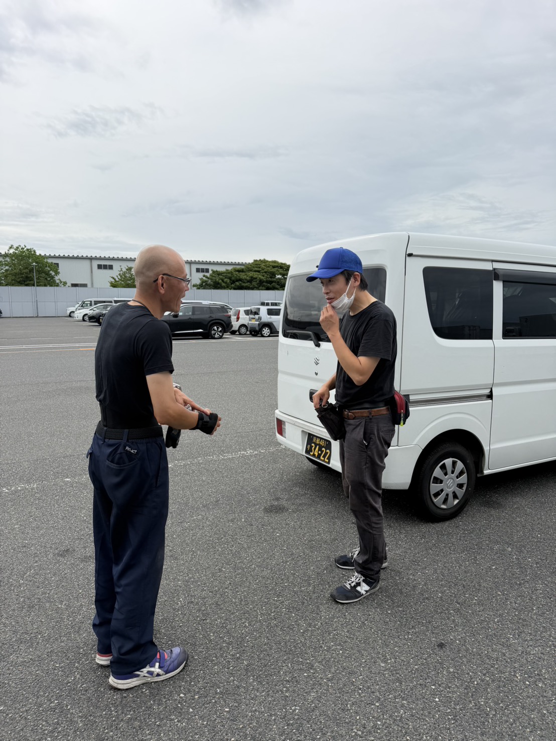 代表とスタッフが車のそばで話す